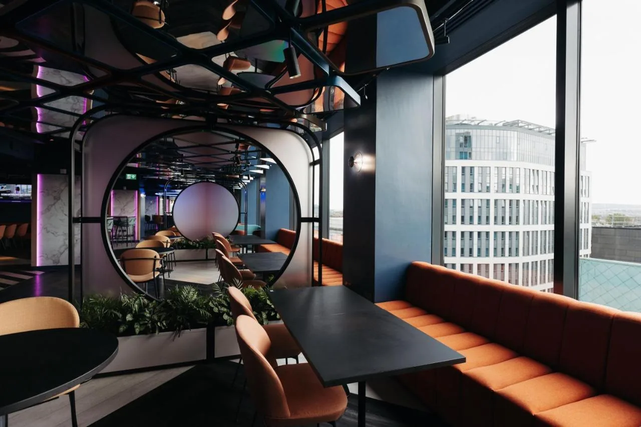 a restaurant with tables and chairs and a large window at Yotel Glasgow in Glasgow
